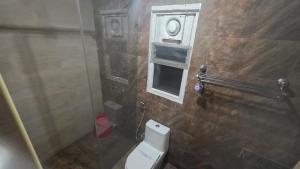 a bathroom with a toilet and a window and a shower at Hotel PAMS in Mayiladuthurai +29 photos