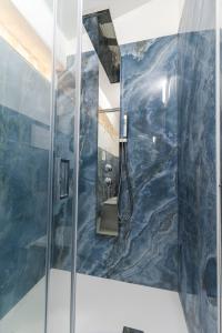 a bathroom with a shower with a blue marble wall at Marechiaro Aparthotel in Marina di Camerota +54 photos