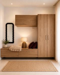 a large wooden cabinet with a lamp in a room at Oikos Apartments in Haraki