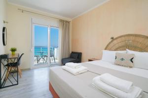 a bedroom with a bed with a view of the ocean at OzioMari Suites in Limenaria