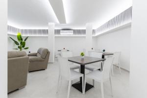 a dining room with a table and chairs and a couch at Marechiaro Aparthotel in Marina di Camerota