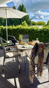 a patio table and chairs with an umbrella at FeWo Lieblingsplatz in Zingst