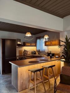 a kitchen with a large island with two bar stools at Skapin house in Skopelos Town