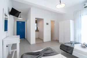 a white bedroom with a desk and a bed at Pleasure Blackbeach Studios in Perissa