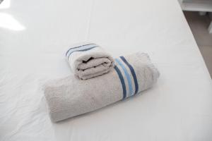 a stack of towels sitting on a bed at Pleasure Blackbeach Studios in Perissa +112 photos