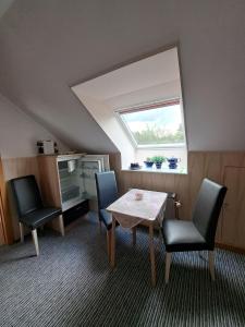 a room with a table and two chairs and a window at Ferienhof Augustenruh in Augustenruh