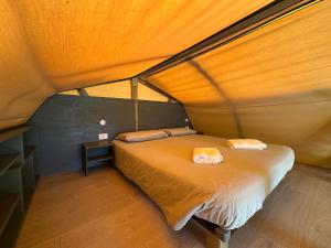 a small bedroom with a bed in a tent at Glamping Camping Rivabella in Lecco