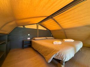 a bedroom with a bed with a wooden ceiling at Glamping Camping Rivabella in Lecco +72 photos