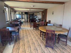 a dining room with tables and chairs in a restaurant at Kibuli beijing hotel in Kampala