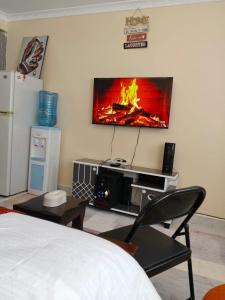a room with a tv hanging on the wall at BnB Studio Oasis Homes Machakos in Machakos