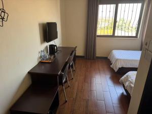 a hotel room with a desk and a bed and a room with a bedskirts at Kibuli beijing hotel in Kampala