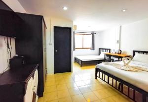 a room with two beds and a table and a door at Patong Canal Villa 308 in Patong Beach