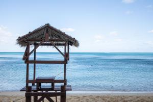 a chair and umbrella on a beach with the ocean at 恩納マリンビューパレス in Onna +21 photos