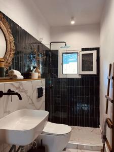 a bathroom with a sink and a toilet and a window at Skapin house in Skopelos Town +40 photos