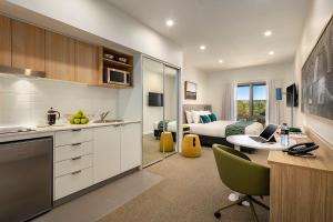 a kitchen and a bedroom with a bed and a desk at Quest Griffith in Griffith