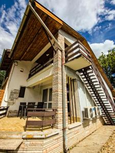 a house with a porch with a bench on it at Nyugágy Apartman in Gárdony