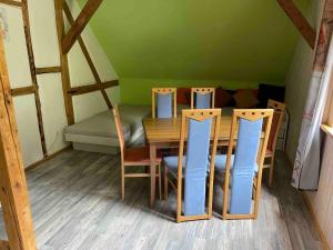 a dining room with a table and chairs and a bed at Waldblick in Neresheim