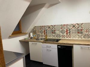 a kitchen with a sink and a tile wall at Waldblick in Neresheim +10 photos