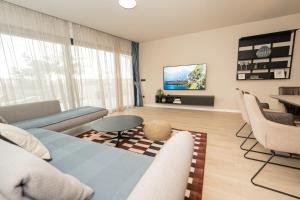 a living room with a couch and a tv at Vila Marila in Stara Novalja