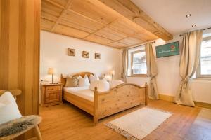 a bedroom with a bed in a room with wooden ceilings at Das Krumerhaus in Aschau