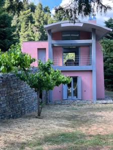 a pink house with a tree in front of it at Seta Forest House in Séta