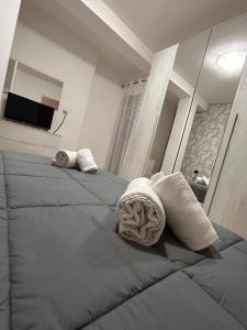 a bedroom with two beds with towels and a mirror at Incanto Stabiese in Castellammare di Stabia