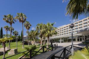 a large building with palm trees in front of it at RVHotels Ametlla Mar in L'Ametlla de Mar