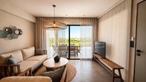 a living room with a couch and a table at Summer Scents Villa Sani by Granari Rentals in Sani Beach