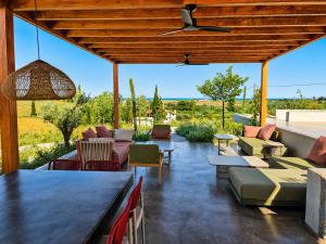 an outdoor patio with couches and chairs and a table at Summer Scents Villa Sani by Granari Rentals in Sani Beach