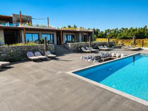 a swimming pool with lounge chairs and a house at Summer Scents Villa Sani by Granari Rentals in Sani Beach