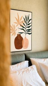 a picture of two vases on the wall above a bed at Summer Scents Villa Sani by Granari Rentals in Sani Beach +19 photos
