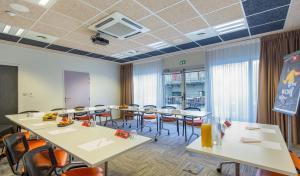 a conference room with tables and chairs in it at Ibis Clermont-Ferrand Centre Stade in Clermont-Ferrand