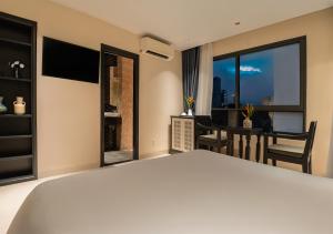 a bedroom with a bed and a dining room at Jolia Nha Trang Hotel in Nha Trang