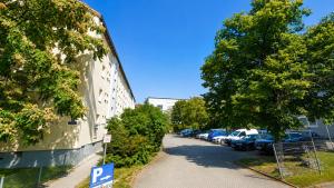 a parking lot with cars parked next to a building at Mete Stays - Modern - Workspace - Cool location in Ingolstadt