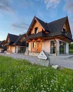 a house with a gambrel roof at Domki Tomanova - Premium Chalets in Dzianisz