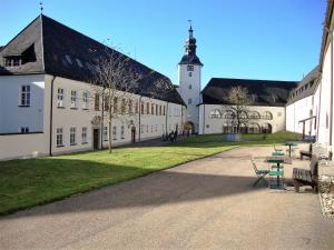 a large white building with a clock tower and a table at Benediktinerstift Michaelbeuern in Michaelbeuern +117 photos