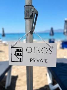a sign on a pole at the beach at Oikos Apartments in Haraki