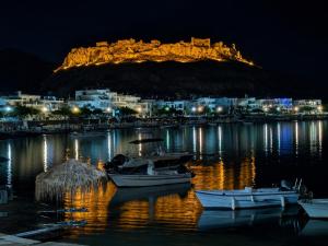 a harbor with boats in the water at night at Oikos Apartments in Haraki +26 photos