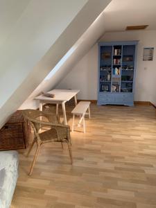 a attic room with a table and chairs and a desk at Maison 400m de la plage in Crozon