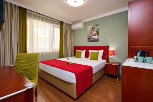 a hotel room with a bed with a red blanket at Art Green Boutique Hotel in Varna City