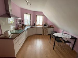 a kitchen with pink walls and a table and chairs at Ferienwohnung Ahrtalfreude in Sinzig