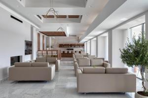 a waiting room with white couches and tables and windows at Airotel Achaia Beach in Patra