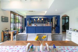 a kitchen with blue cabinets and a table with chairs at Rimwiang in Chiang Mai