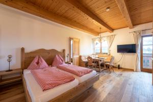 a bedroom with a bed and a dining room at Kinderparadies Bachbauer in Mondsee