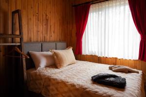 a bedroom with a bed with red curtains at Rino hauss in Fındıklı