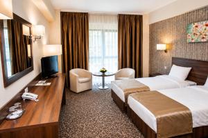 ein Hotelzimmer mit Bett und Fernseher in der Unterkunft Hotel Arnia in Iaşi + 53 Fotos