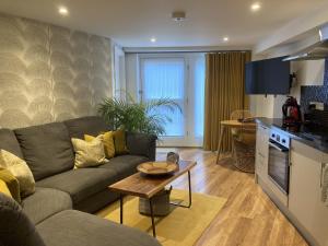 a living room with a couch and a table at Streamside Apartments in Yeovil