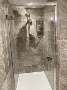 a shower with a glass door in a bathroom at Streamside Apartments in Yeovil