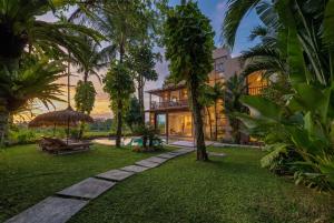 an exterior view of a house with palm trees at Sealuna Villas in Tanah Lot