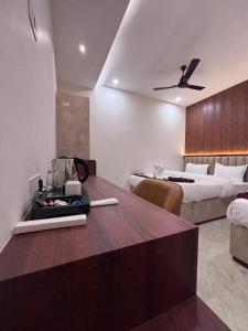 a hotel room with a bed and a kitchen with a table at Raghuwar Palace in Ayodhya